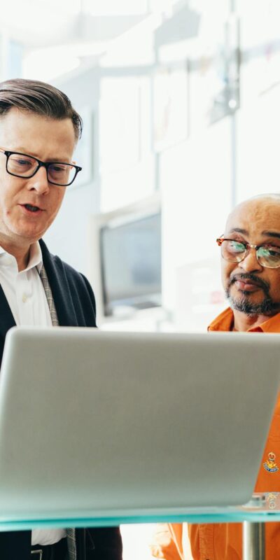 Man Using Silver Laptop Beside Another Man